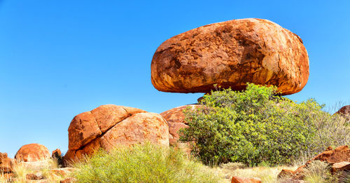 Rock formation amidst rocks against clear blue sky