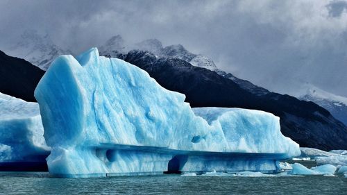 Glacier in sea against mountain