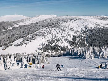 People on snow covered mountains against sky