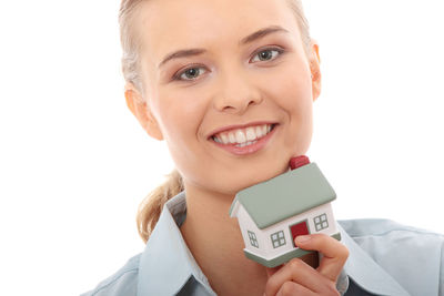 Portrait of a smiling young woman against white background