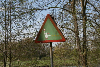 Low angle view of road sign against trees