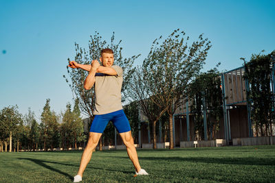 Full length of man exercising on field