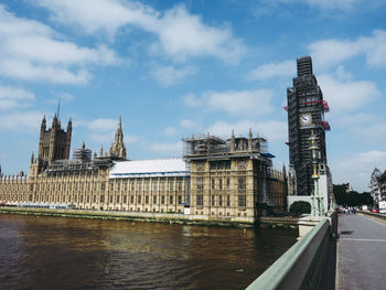 Tower bridge over river against buildings in city