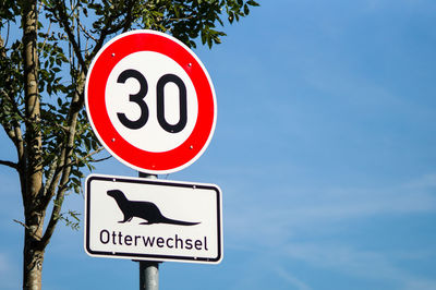 Low angle view of road sign against sky