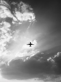 Low angle view of silhouette airplane against sky