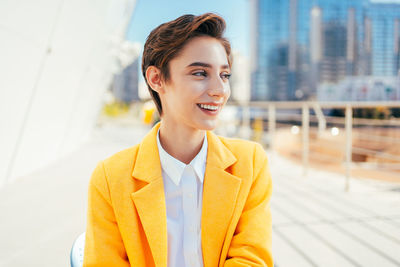 Portrait of young man standing against building