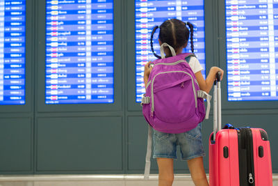 Cute girl looking at arrival departure board
