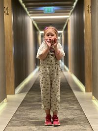 Portrait of young woman standing in corridor