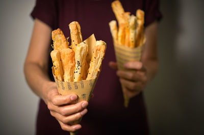 Salted cheese straws and sesame seeds in a paper cone