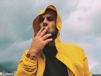 Portrait of young man wearing sunglasses against sky