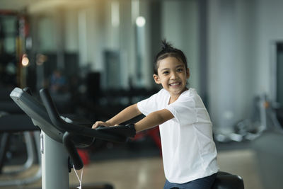 Portrait of cute girl exercising at gym