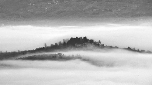 View of fog over mountain against cloudy sky