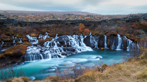 Scenic view of waterfall against sky