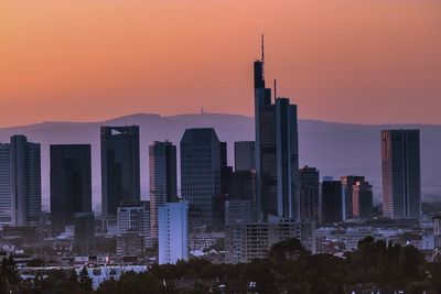 Skyscrapers in city at sunset