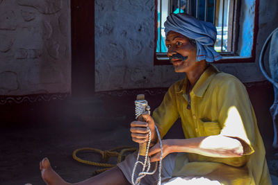 Woman holding camera while sitting outside temple