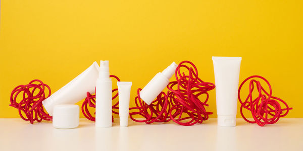 Close-up of objects on table against yellow background