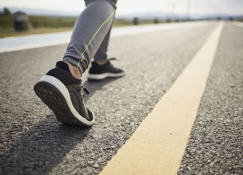 Low section of man skateboarding on road