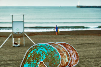 Rusty metal on beach against sky