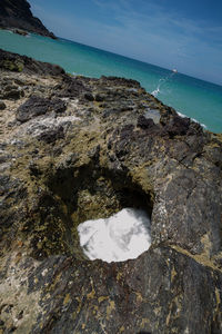 Rock formation on beach against sky