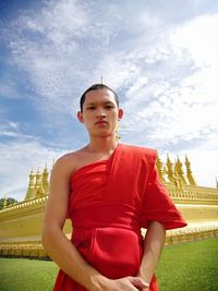 Portrait of boy standing against sky