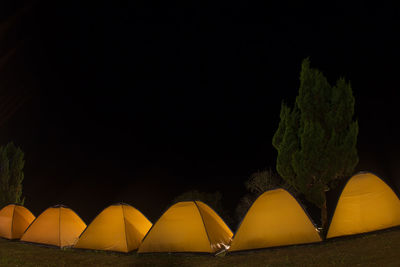 Yellow tent against sky at night