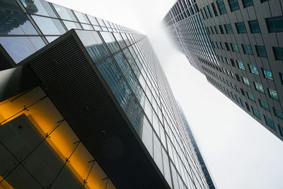 Directly below shot of modern buildings against clear sky