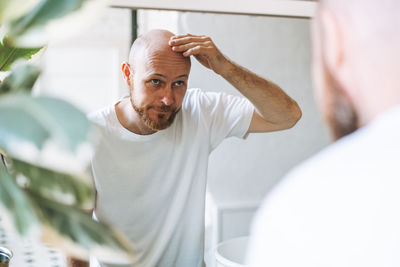 Portrait of young man standing in bathroom