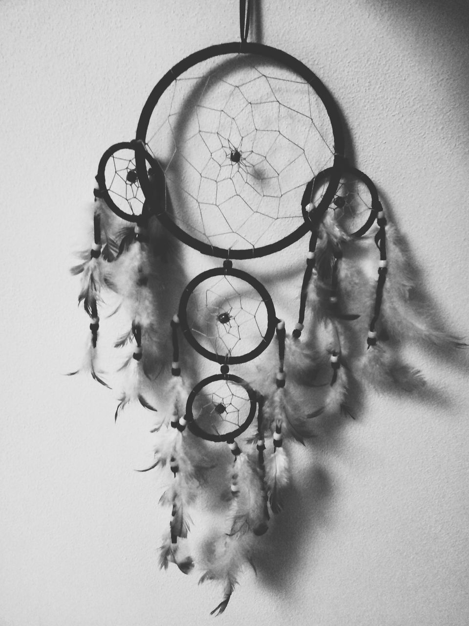 indoors, art and craft, hanging, art, decoration, creativity, close-up, still life, wall - building feature, circle, ornate, home interior, design, human representation, decor, no people, studio shot, single object, lighting equipment, chandelier