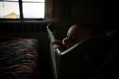 Baby girl looking away from crib at home