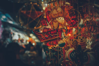 Close-up of decorations hanging for sale at night