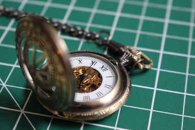 Close-up of pocket watch on cutting mat