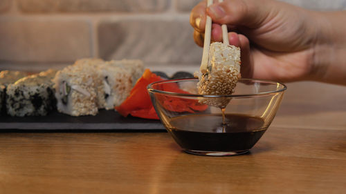 Close-up of hand holding food on table