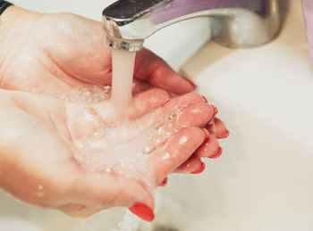 Cropped image of hand touching water at home