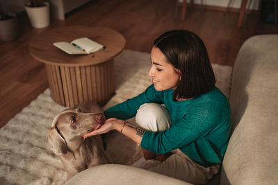 Young woman sitting on sofa at home