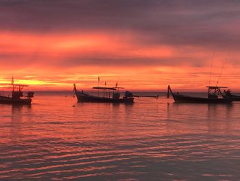 Sailboats in sea against sky during sunset