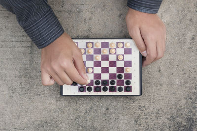 Cropped hand playing chess on table