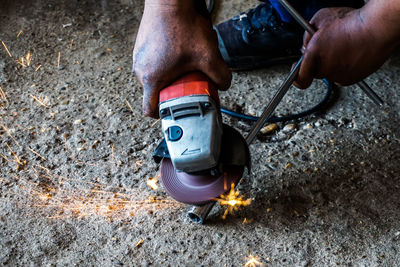 Cropped image of worker sawing metal