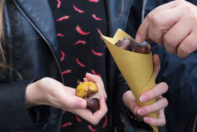 Midsection of friends holding chestnuts