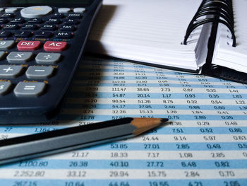 Close-up of pencil by book and calculator