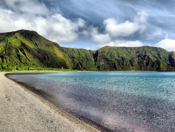 Scenic view of road by mountains against sky