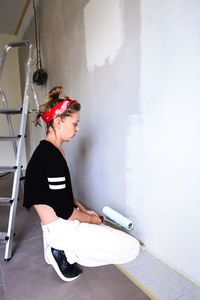 Girl paints the walls in the house