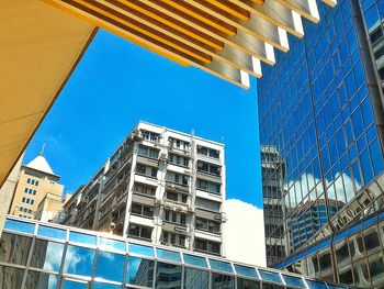 Low angle view of modern building against blue sky