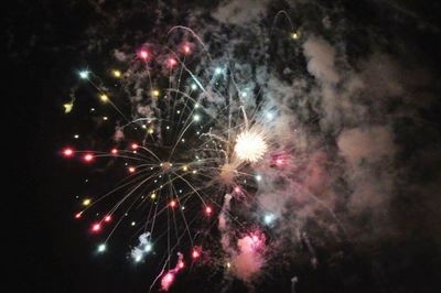 Low angle view of firework display at night