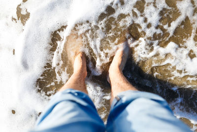 Blond guy tourist in jeans enjoying the beach and the sea