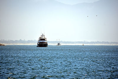 Sailboat sailing on sea against clear sky