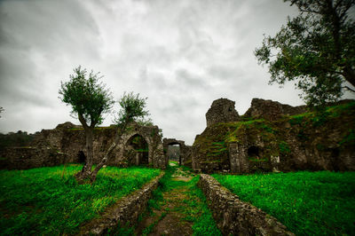 Old ruins on field against sky