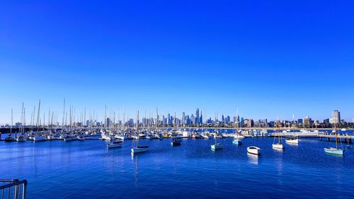 Sailboats in sea against clear blue sky