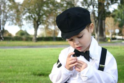 Close-up of boy looking at needle in park