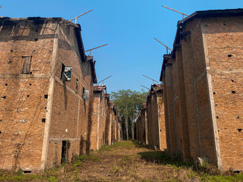 Low angle view of old buildings against blue sky