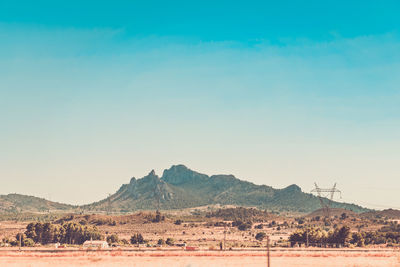 Scenic view of desert against clear blue sky